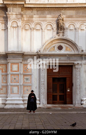 Lone man in a black cape stands outside the Chiesa di San Zaccaria, Castello, Venice, Italy Stock Photo