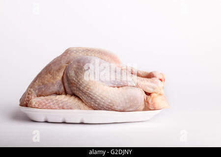Raw whole plucked chicken ready for cooking on a plastic styrofoam disposable punnet Stock Photo