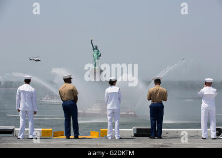 US Sailors and Marines aboard the amphibious assault ship USS Bataan man the rails to salute the Statue of Liberty during the parade of ships part of the annual Fleet Week May 25, 2016 in New York City, NY. Stock Photo
