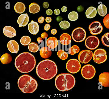 Variety of Sliced and Whole Citrus Fruit on Tray, High Angle View Stock Photo