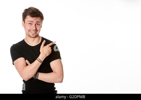 Excited young man points to space for text, isolated on white Stock Photo