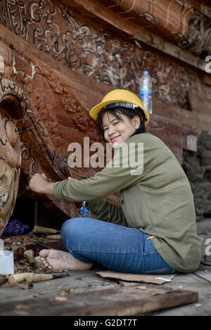 Young female builder sculpting and carving wood at the Sanctuary of truth Buddhist Hindu temple. Pattaya Thailand S. E. Asia Stock Photo