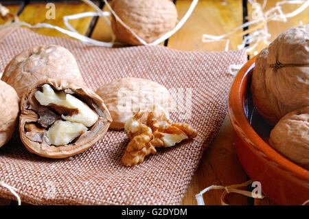 Group of healthy walnuts in shell and shelled exposed on a wooden table Stock Photo