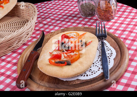 Wood plate with pasrty with red pepper fork and knife with spices in the background Stock Photo