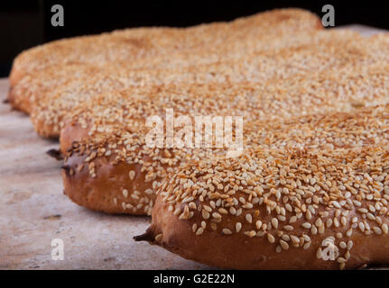 Sesame buns in a row on used wood plate Stock Photo