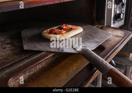 Vegetble pastry going into hot oven on spoon Stock Photo