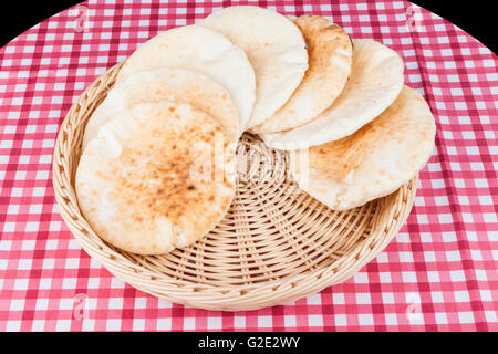 Pita in round basket on red table and black background Stock Photo