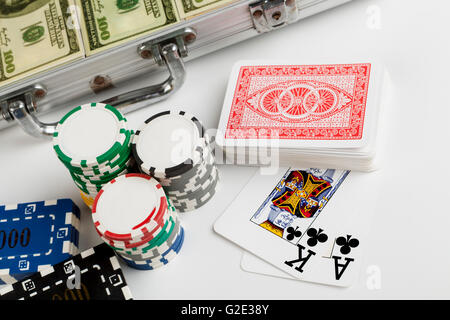 Casin ochips with briefcase full with dollars in the backgrouns and playing cards isolated on white Stock Photo