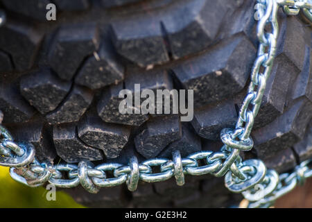 Close up shot of some chains wrapped around a car's tire. Stock Photo