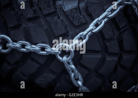 Close up shot of some chains wrapped around a car's tire. Stock Photo