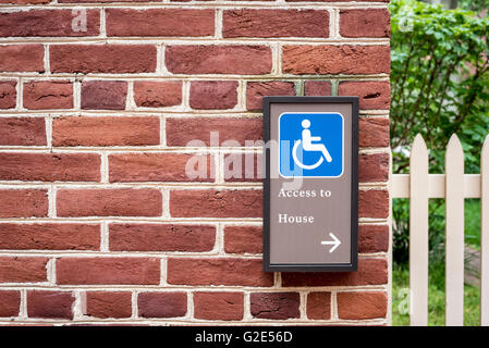 Handicap access sign on brick wall Stock Photo
