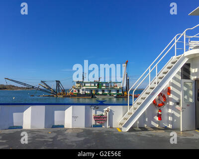 ferry boat with view of a nearby working barge Stock Photo