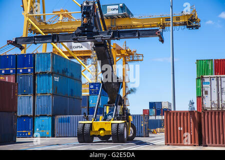 reach stacker lifting containers in a dock Stock Photo