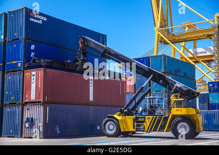 reach stacker lifting containers in a dock Stock Photo