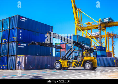 reach stacker lifting containers in a dock Stock Photo