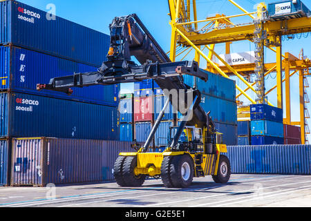 reach stacker lifting containers in a dock Stock Photo