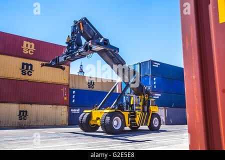 reach stacker lifting containers in a dock Stock Photo