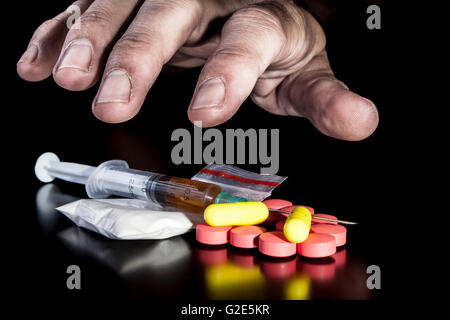 Dirty hand grabbing nartotics on dark background with reflection Stock Photo