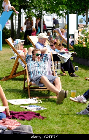 Hay Festival, Wales, UK May 2016 -  Many Festival goers enjoy sitting and relaxing in the sun on the  Festival lawns. Stock Photo