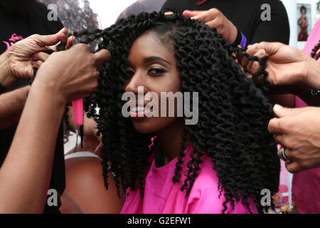 London, UK. 29th May, 2016. London.UK 29 May.2016 A woman has hair done at the Europe's biggest black hair and beauty exhibit at the  Business Design Centre in Islington. Credit:  Thabo Jaiyesimi/Alamy Live News Stock Photo
