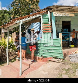 Square view of tourists buying sugar cane juice at a ramshackled cafeteria in Valle De Los Ingenios, Cuba. Stock Photo