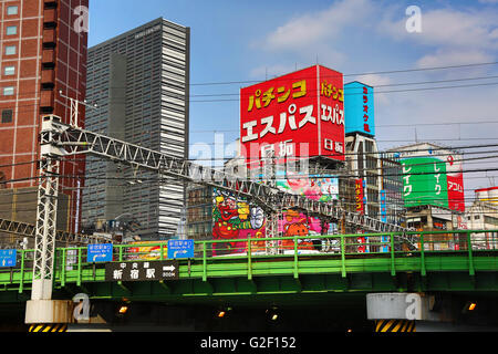 Buildings and advertising signs and railway line in Shinjuku in Tokyo, Japan Stock Photo