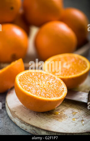 orange fruits halves on wooden board Stock Photo