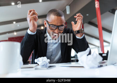 Shouting tired businessman at his desk at the office Stock Photo