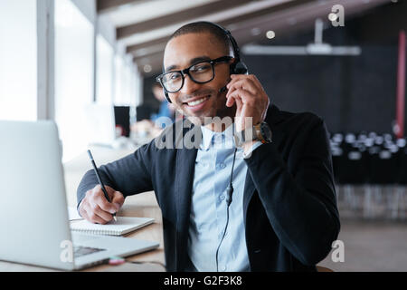Stylish smart businessman using headphones during his work at the office Stock Photo