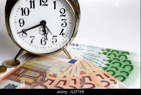 Time is Money concept shot with old mechanical Alarm Clock and Euro Banknotes Stock Photo