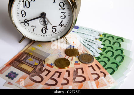 Time is Money concept shot with old mechanical Alarm Clock and Euro Banknotes Stock Photo