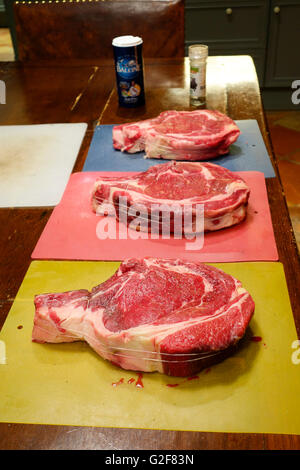 Three massive Rib steaks, cote de boeuf on table before being grilled. France Stock Photo