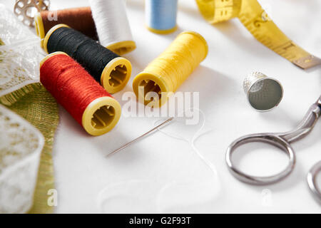 Sewing tools on white fabric background left set.  Horizontal composition. Elevated view Stock Photo