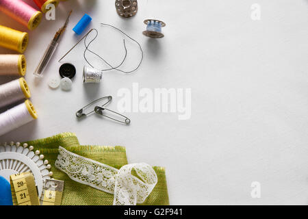 Sewing tools on white fabric background left set.  Horizontal composition. Top view Stock Photo