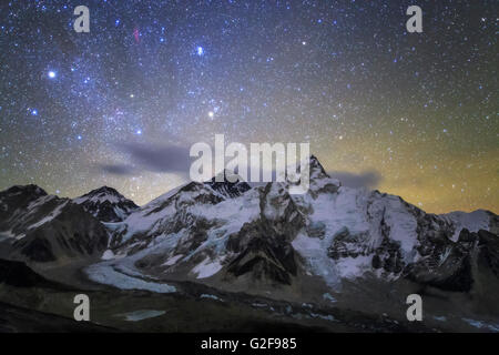 The bright stars of constellation Auriga and Taurus rise above the central Himalayas. Mount Everest (8848m) stand with banner cl Stock Photo