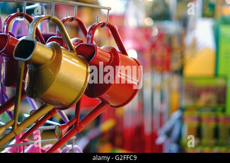 Watering cans in a garden centre shop. Stock Photo