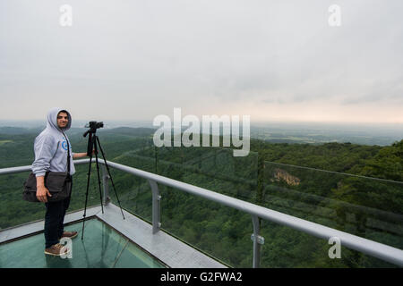 Young man with taking a photo on the top of mountains Stock Photo