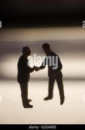 Businessmen Figurines Shaking Hands Stock Photo