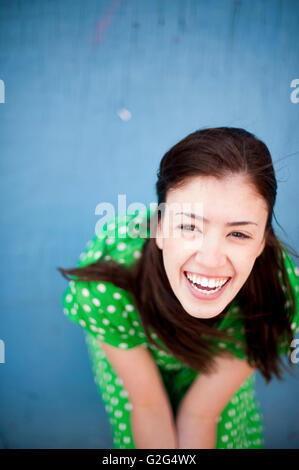 Laughing Young Woman in Green Dress with Polka Dots, High Angle View Stock Photo