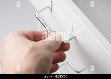The closeup hand opens the drawers Stock Photo