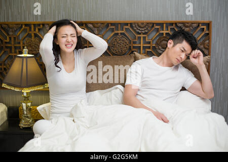 Angry young couple in bed Stock Photo