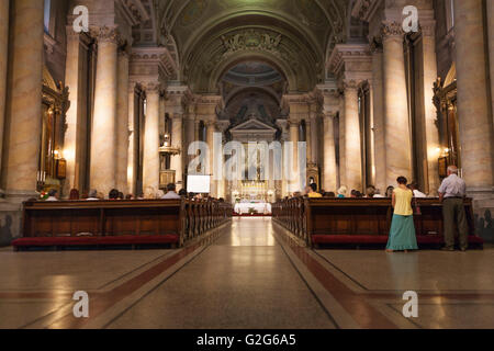 Old Catholic cathedall full with people during pray Stock Photo