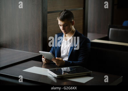 Portrait of a young businessman seeing on his tablet pc in cafe. Stock Photo