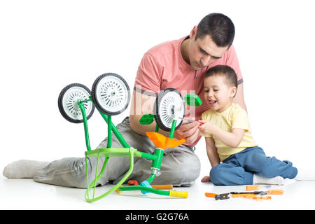 kid boy and his daddy fixing children bike Stock Photo