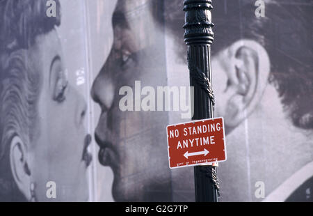 A 'No Standing' parking sign rises in front of a billboard in New York City. Stock Photo