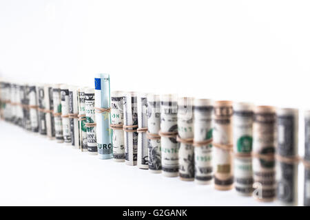 Row of dollar rolls with a euro banknote in the middle isolated on white Stock Photo