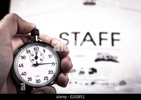 Silver vintage metalic chronometer in a hand with a white staff shirt in the background Stock Photo