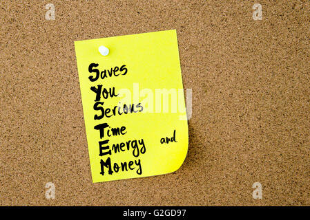 Business Acronym SYSTEM Saves You Serious Time Energy and Money written on yellow paper note pinned on cork board with white thumbtack, copy space available, SYSTEM, Saves, You, Serious, Time, Energy, and, Money Stock Photo
