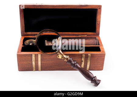 Open wood box with a telescope compass and a magnifying glass isolated on white Stock Photo