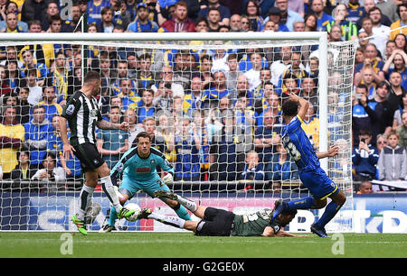 AFC Wimbledon's Lyle Taylor (right) scores his side's first goal of the game during the Sky Bet League Two Play-Off Final match at Wembley Stadium, London. Stock Photo